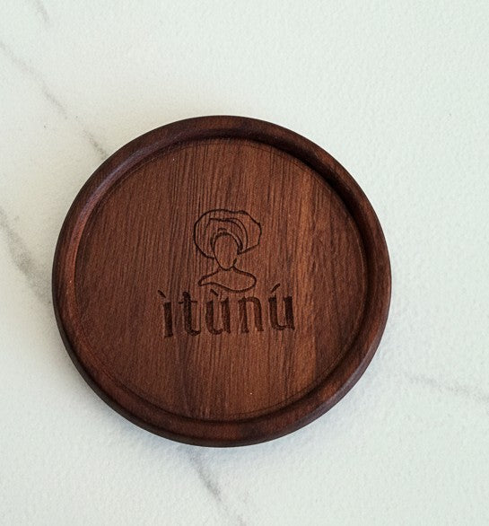 Wooden coaster with 'ìtùnu' branding on a marble surface.