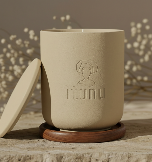 Beige ceramic cup with wooden base and lid on a stone surface with blurred aromatherapy white flowers in the background