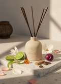 Reed diffuser with plums, agarwood, Osmanthus flower, Bergamot on a marble surface